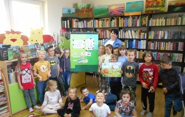 Dzieci całą grupą stoją wraz z Panią przy tablicy z  wykonanymi zadaniami.