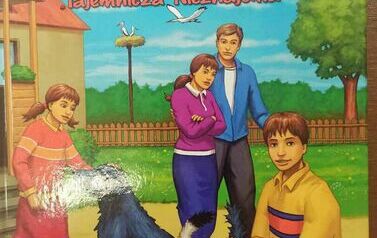 Okładka książki " Nasz przyjaciel Łatek" przedstawiająca rodzinę i dw&oacute;ch piesk&oacute;w przy domu.