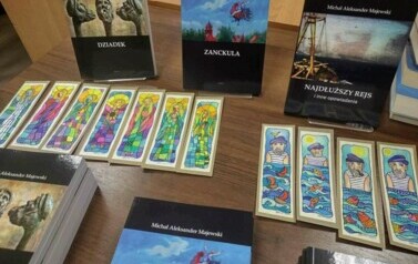 Na stole są wyłożone do sprzedania książki autora i własnoręcznie robione zakładki do książki.