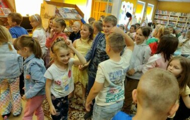 Grupa dzieci stoi obok siebie i się uśmiecha.