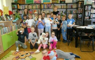 Zdjęcie grupowe dzieci z bibliotekarką i wychowawcą klasy.