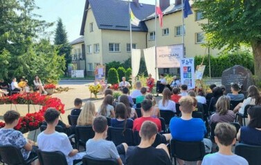 Widok z oddali na publiczność i czytających.
