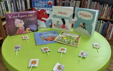 Na okrągłym stoliku są wyłożone bajki o tematyce miłosnej i lizaki w serduszka.