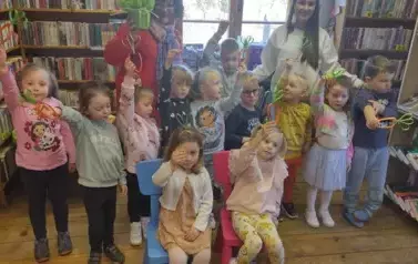 Dzieci stoją w grupie razem z Panią wychowawczynią i z Panią prowadzącą i trzymają w ręku zrobione z papieru marchewki