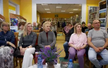 Krzesła w bibliotece są zajętę przez czytelnik&oacute;w przybyłych na spotkanie.