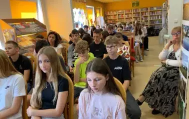 Twarze licznej młodzieży siedzącej na krzesłach, po prawej stronie siedzi Pani Sekretarz Gminy.