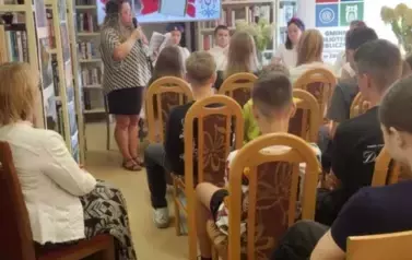 Młodzież siedzi na krzesłach,z lewej strony siedzi Pani Sekrestarz Gminy, a z przodu Pani Kierownik Biblioteki na koniec czyta jeden z tren&oacute;w Jana Kochanowskiego.