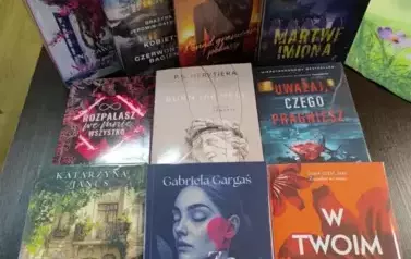 Na stole leży dziesięć nowych książek z widocznymi tytułami.
