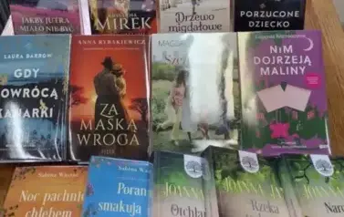 Na stole są rozłożone nowe książki z widocznymi tytułami.