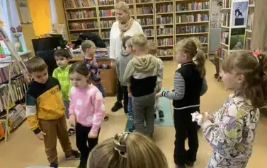 Dzieci wraz ze swoją Panią stoją w rozsypce w bibliotece w Zblewie