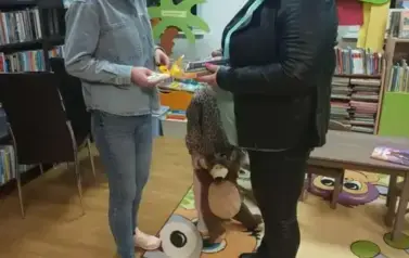 Aneczka Bajeczka wręcza bibliotekarce podziękowanie i pięknie zapakowane książeczki w prezencie.