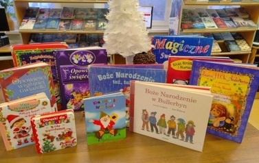 Na stole są wystawione bajki świąteczne i mała biała choinka