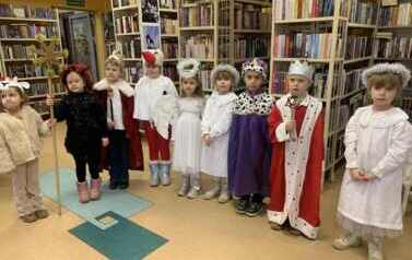 Kolędnicy stoją dużą grupą i śpiewają kolędę