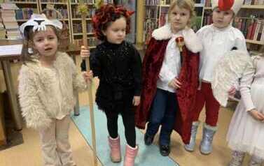 Dzieci przebrane za Trzecch Kr&oacute;li, pastuszka i diabła stoją w bibliotece