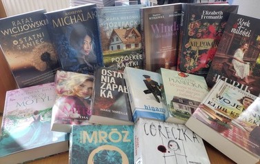 Na stole są rozłożone nowe książki z widocznymi tytułami.