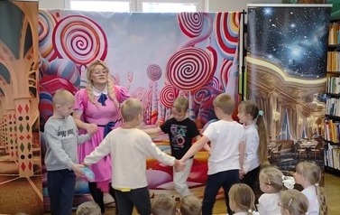 Zosia z pięciorgiem dzieci z publiczności tańczą w k&oacute;łeczku.