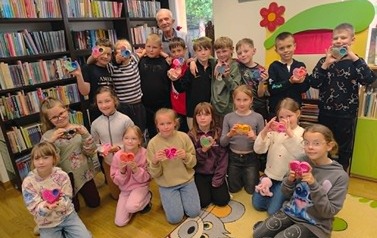 Dzieci stoją razem z Panem Marianem Opatowskim i trzymają swoje pomalowane gipsowe serduszka.