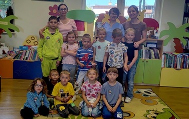 Dzieci stoją w grupie z Panią z Przedszkola, z Panią Gabrysią i z bibliotekarką.