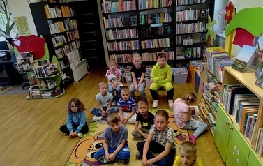 Grupa dzieci siedząca na dywanie.