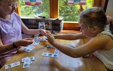 Dwie dziewczynki układają przy stoliku Domino obrazkowe