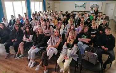 Publiczność łlodzieżowa siedząca na krzesłach słuchająca Narodowego Czytania