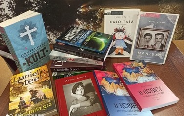 Nowe książki bajki ułożone na stoliku z widocznymi tytułami. W tle pejzaż z zachodem słońca.