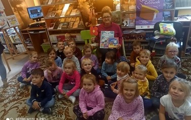 Grupowe zdjęcie dzieci z Panią bibliotekarką.