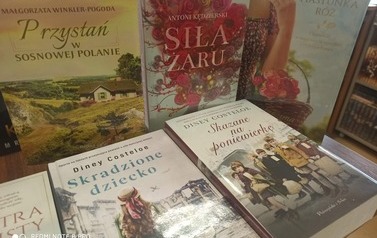 Nowe książki położone na stoliku, widać okładki z tytułami