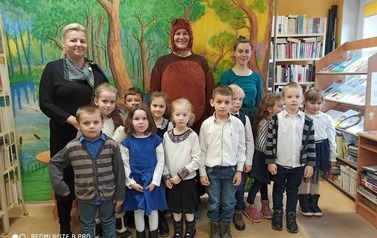 Grupa dzieci stoi z nauczycielką i aktorami teatrzyku
