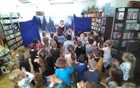 Aktorka pokazuje na środku kroki taneczne i dzieci Ją naśladują