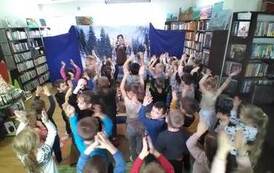 Aktorka pokazuje na środku kroki taneczne i dzieci Ją naśladują