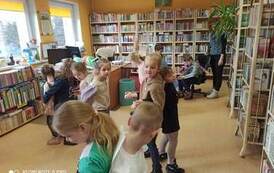 Cztery pary tańczących dzieci ustawionych do siebie plecami i ze złączonymi rękoma .