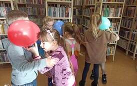 Trzy pary dzieci tańczących twarzą do siebie i głowami trzymające balony.