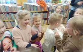 Dzieci stoją uśmiechnięte w rozsypce.