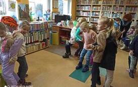 Dzieci dobrane w pary i tańczące, ustawione są do siebie plecami.