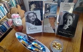 Na stole wystawione są ksiązki o kobietach, cukierki i zwinięte w rulonik aforyzmy o kobietach.