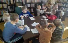 Dzieci siedzą przy stołach i kolorują obrazki przedstawiające postaci z baśni Andresrena.