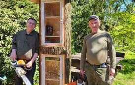 Przy świeżo zbudowanej biblioteczce w Wirtach stoją Panowie z piłami w rękach, kt&oacute;rzy ją zbudowali.