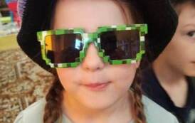 Dziewczynka w warkoczykach,w fioletowym kapeluszu i zielonych okularach