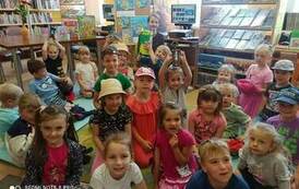 Zdjęcie grupowe dzieci z Panią Gosią trzymającą w ręku zgniatarkę do butelek.