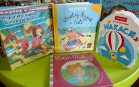 Na zielonym okrągłym stoliku są położone bajki dla dzieci z widocznymi tytułami.