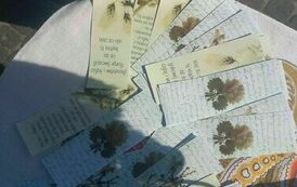 Na stoliku leżą zakładki do książki z rękopisem lub cytatem Elizy Orzeszkowej.