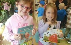 Dwie dziewczynki pokazują książki o jesieni.