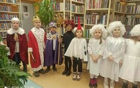 Kolędnicy stoją w grupie i śpiewają kolędę.