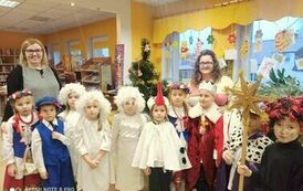 Kolędnicy stoją w bibliotece wraz ze swoją Panią i bibliotekarką.