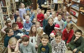 Dzieci siedzą na dywanie z Szymonem G&oacute;ralczykiem - Karawaną Opowieści. 