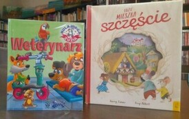 Na stole są wyłożone pionowo dwie książeczki pt. "Weterynarz" i "Gdzie mieszka szczęście".