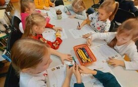 Przy stołach siedzą dzieci i robią karty pracy.