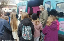 Przy busie nagraniowym stoi grupa młodzieży i prowadzący warsztaty Iwona Skwarek i Piotr Martin.