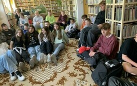 Młodzież siedzi na dywanie i słucha opowieści Michała Szulima